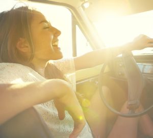 Happy young woman driving